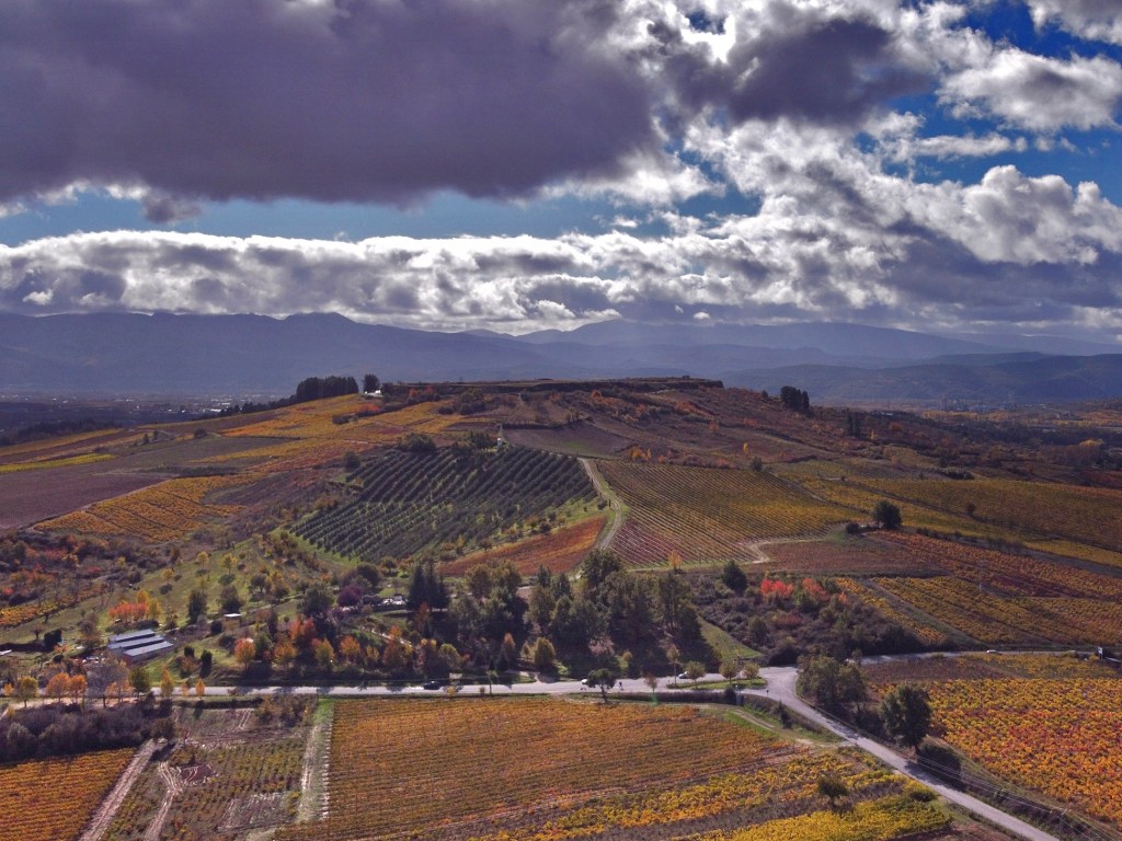 A vista de dron de la Peña del Castro (Castroventosas) rodeada viñedos en la estación otoñal, Pieros, Cacabelos, El Bierzo, León, Castilla y León, España.