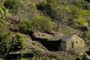 Casa berciana con su parte trasera pegada a la ladera de una montaña en Cabeza de Campo, Sobrado, El Bierzo, León, Castilla y León, España.