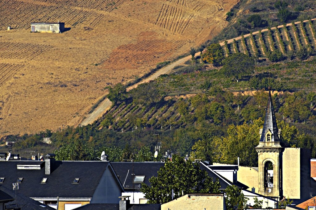 Torre campanario de la Iglesia Santa Maria con las faldas de Castroventosa al fondo en Cacabelos, El Bierzo, León, Castilla y León, España.
